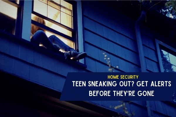 A person climbing out of a second-story window at night