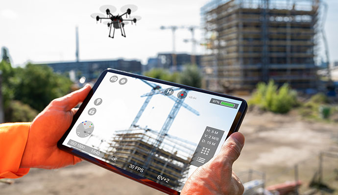 Construction worker viewing drone feed on tablet