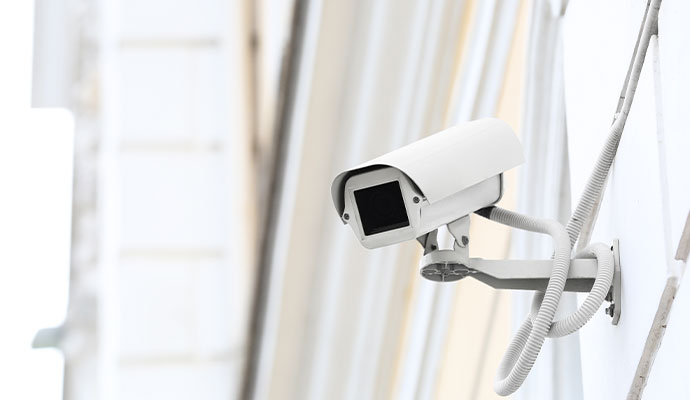 White camera with hood and conduit on wall
