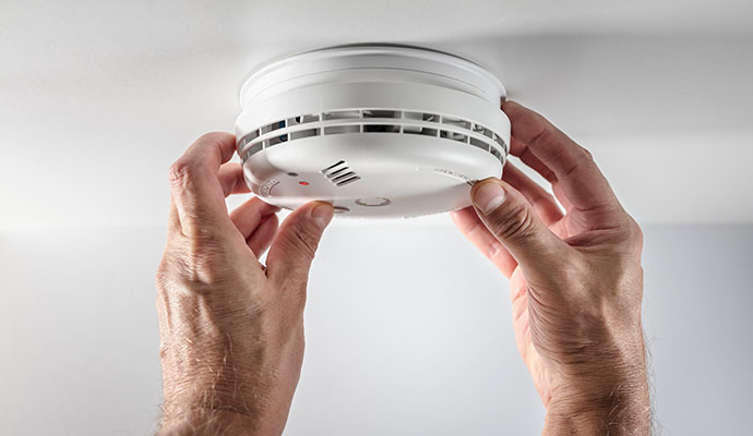 A professional installing smoke detector system
