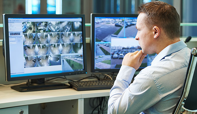 Operator monitoring live CCTV camera feeds on screens