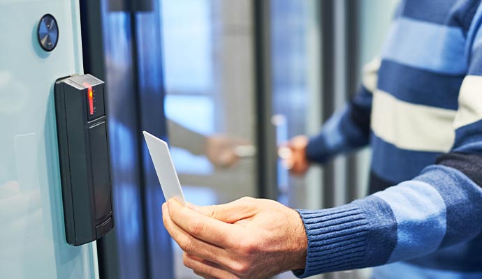 Person using a key card reader to access a property