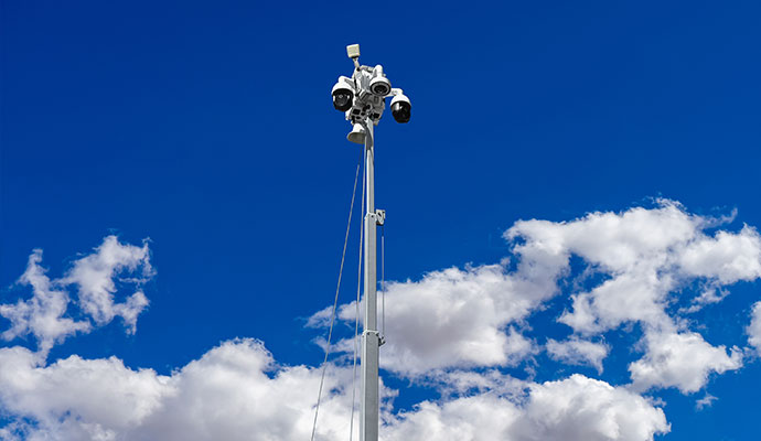 Low angle view of security cameras mounted on high mast