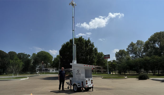 Man standing next to Sentry trailer to show scale of mast