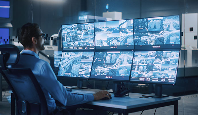 Man watching security camera feeds on video wall