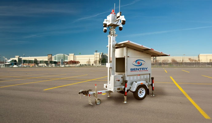 Sentry mobile surveillance trailer with solar panels in a parking lot