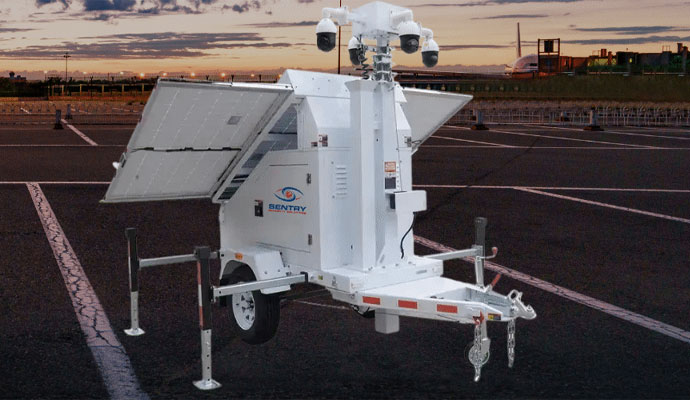 Sentry surveillance trailer with solar wings open at sunset