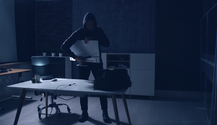 Thief stealing a desktop computer monitor from an office